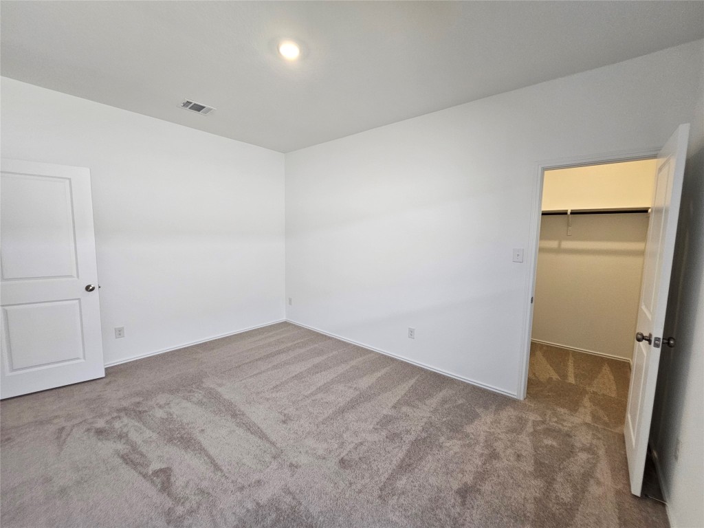 856 Rancho Del Cielo Loop Jarrell, TX 76537 - Photo 25 of 35 an empty room with closet and wooden door