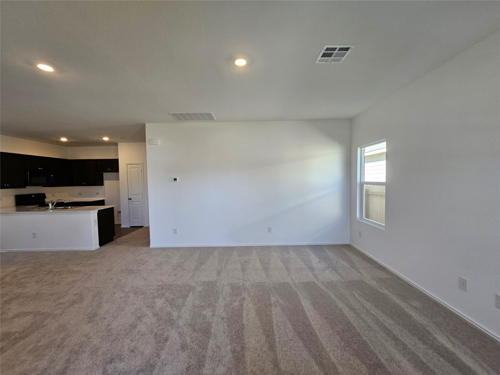 856 Rancho Del Cielo Loop Jarrell, TX 76537 - Photo 4 of 35 an empty room with kitchen view and a window