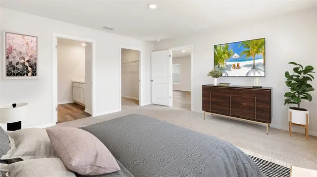 a bedroom with a bed a couch and painting on the wall