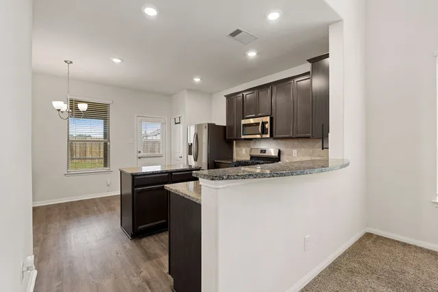a kitchen with a refrigerator a sink and cabinets