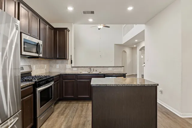 an empty room with windows and ceiling fan