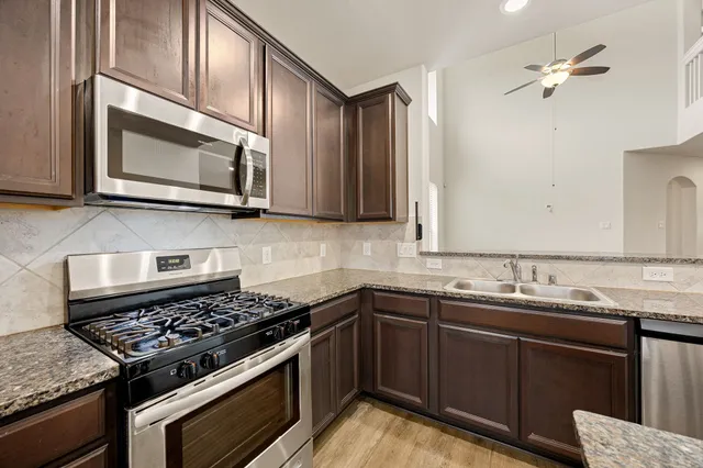an empty room with chandelier fan and ceiling fan