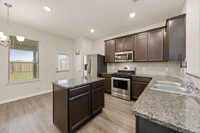 a bathroom with a granite countertop sink a mirror and shower