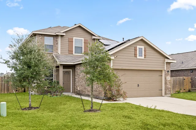 an empty room with wooden floor and a kitchen