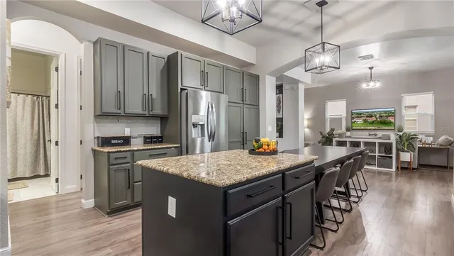 a living room with furniture a large window and wooden floor