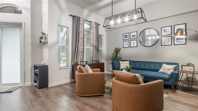 a living room with furniture a window and wooden floor
