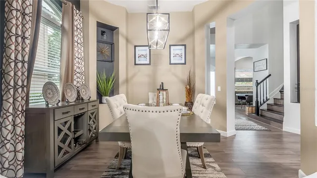 a kitchen with stainless steel appliances a dining table chairs stove refrigerator and cabinets