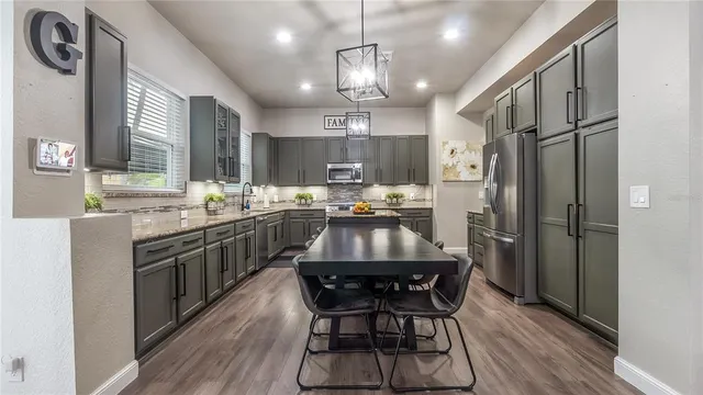 a kitchen with a dining table chairs stainless steel appliances and cabinets