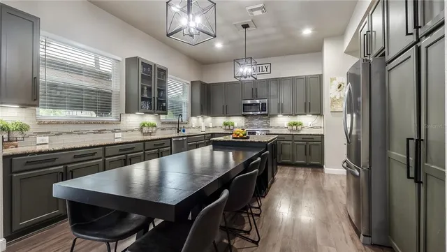 a kitchen with stainless steel appliances granite countertop a sink a stove and a microwave