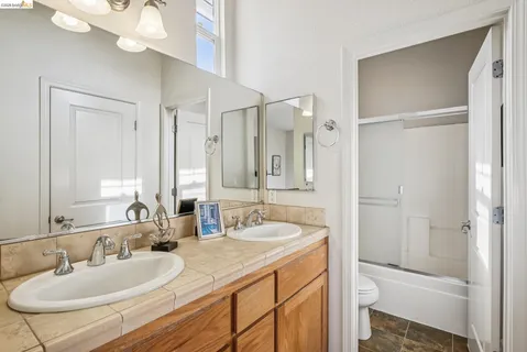a bathroom with a sink a toilet and a mirror