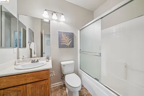 a bathroom with a granite countertop toilet sink and a mirror