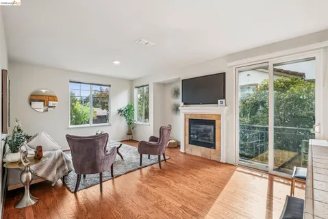 a living room with furniture a fireplace and a floor to ceiling window