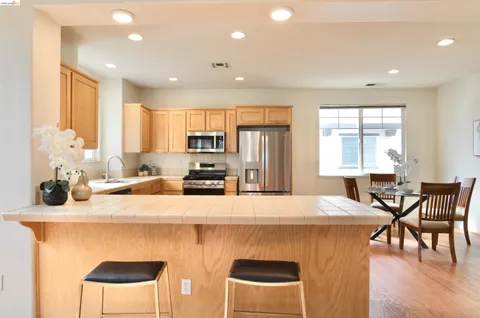 a kitchen with stainless steel appliances kitchen island granite countertop a kitchen island a stove a table and chairs in it