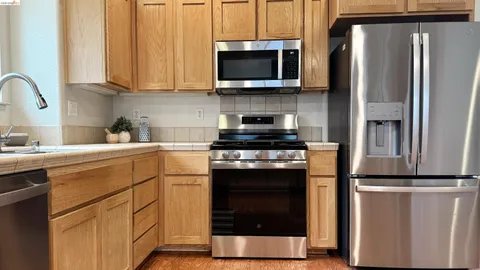 a kitchen with stainless steel appliances granite countertop a refrigerator stove and microwave