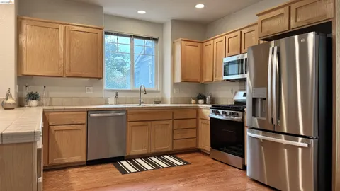 a kitchen with granite countertop a refrigerator stove top oven and sink