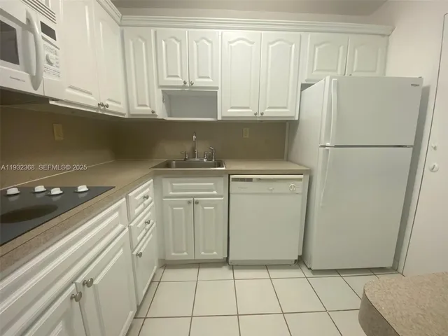 a kitchen with a white cabinets and white appliances