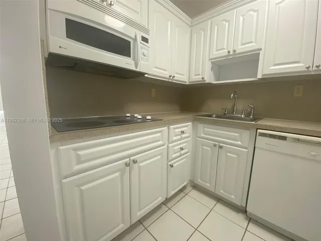 a kitchen with white cabinets and white appliances