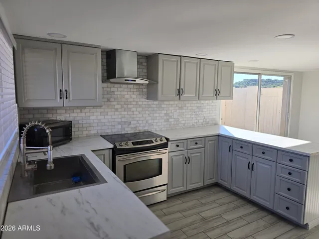 a kitchen with stainless steel appliances granite countertop a stove a sink and a microwave