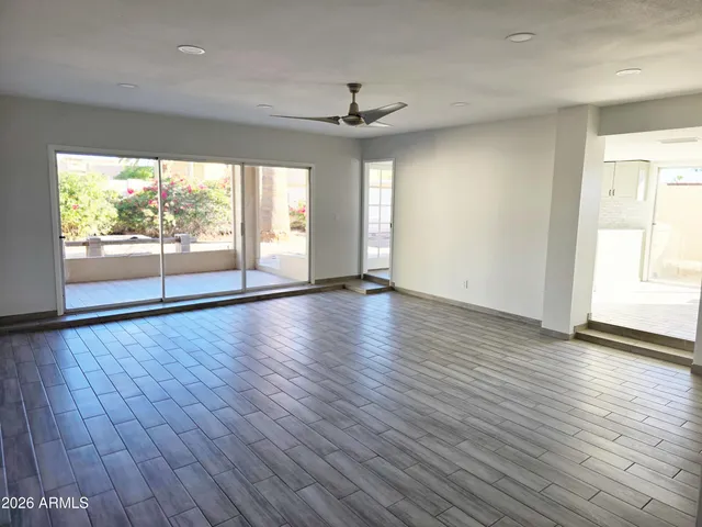 an empty room with wooden floor and windows