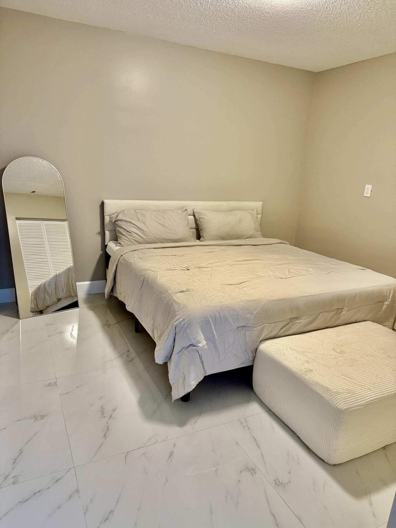 14523 Flamingo Road Loxahatchee Groves, FL 33470 - Photo 47 of 50 a spacious bedroom with a bed and chair