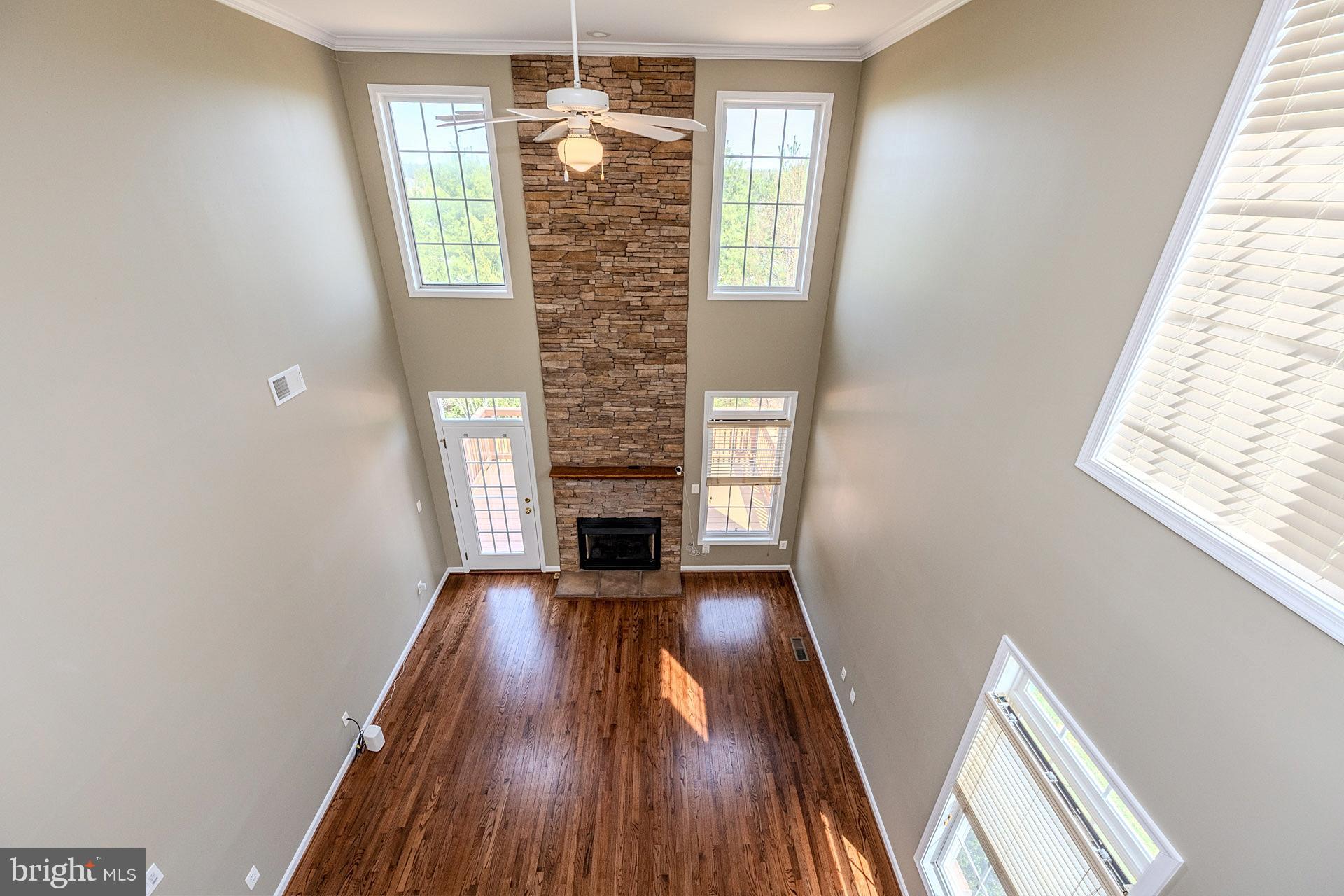 230 West Ridge Court Warrenton, VA 20186 - Photo 23 of 44 an empty room with wooden floor fireplace and windows