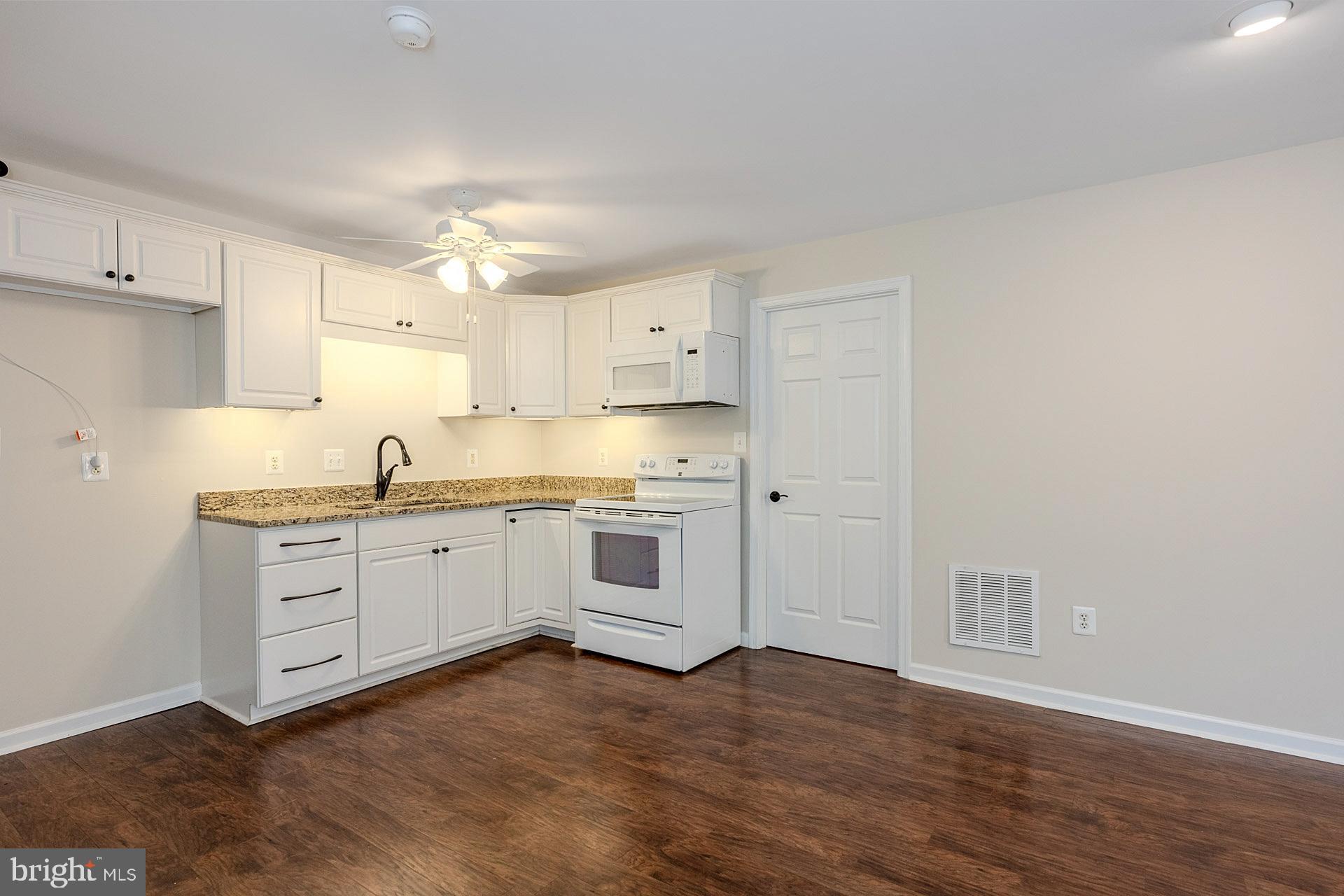 230 West Ridge Court Warrenton, VA 20186 - Photo 32 of 44 a kitchen with granite countertop white cabinets and white appliances