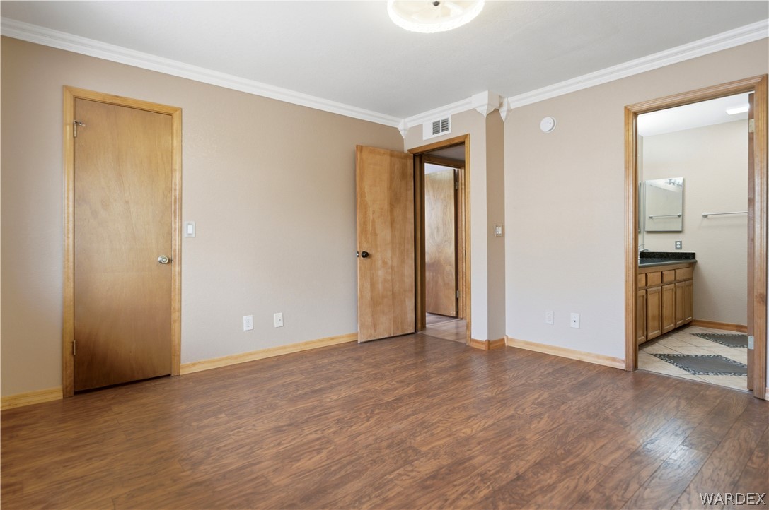 2719 Ricca Court Kingman, AZ 86401 - Photo 15 of 33 a view of an empty room with wooden floor and a bathroom