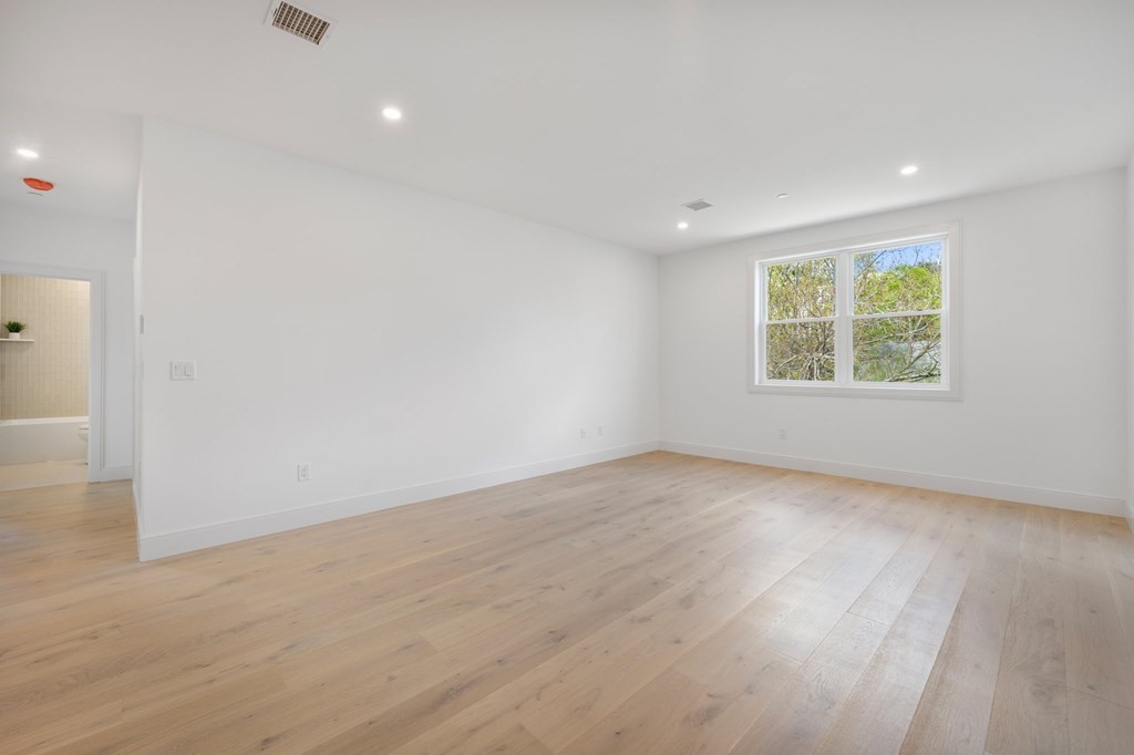 5245 Washington Street, Unit 6 Boston, MA 02132 - Photo 11 of 22 an empty room with wooden floor and windows