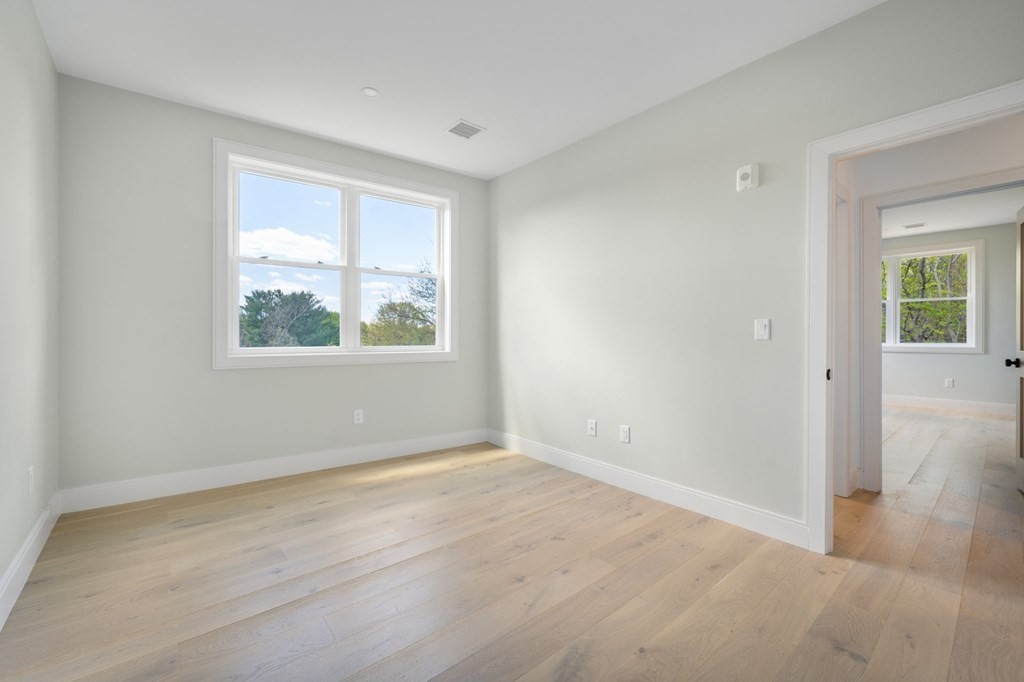 5245 Washington Street, Unit 6 Boston, MA 02132 - Photo 17 of 22 a view of an empty room with wooden floor and a window