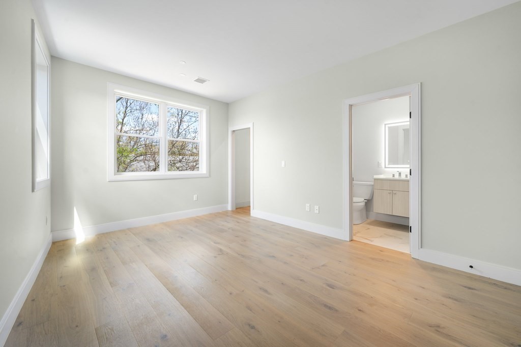 5245 Washington Street, Unit 6 Boston, MA 02132 - Photo 18 of 22 wooden floor in an empty room with a window