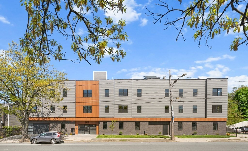 5245 Washington Street, Unit 6 Boston, MA 02132 - Photo 2 of 22 a front view of a building with lot of cars and trees