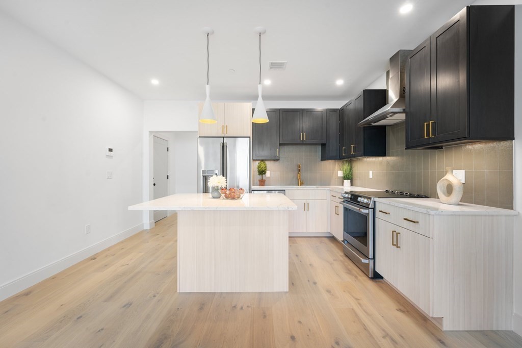 5245 Washington Street, Unit 6 Boston, MA 02132 - Photo 6 of 22 a kitchen with stainless steel appliances granite countertop a sink a stove and a wooden floors