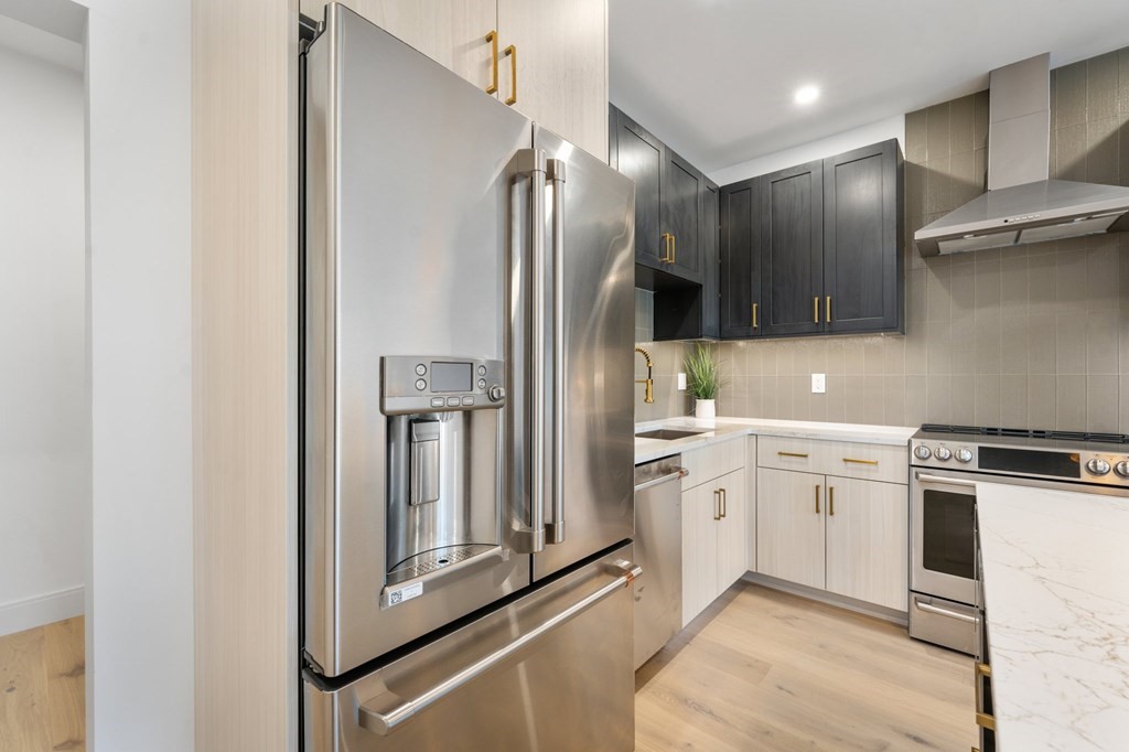 5245 Washington Street, Unit 6 Boston, MA 02132 - Photo 9 of 22 a kitchen with cabinets and stainless steel appliances