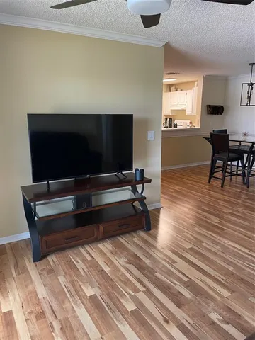 a living room with furniture flat screen tv and wooden floor
