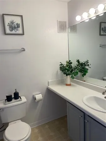 a bathroom with a sink toilet and a mirror