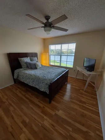 a bedroom with a bed and wooden floor