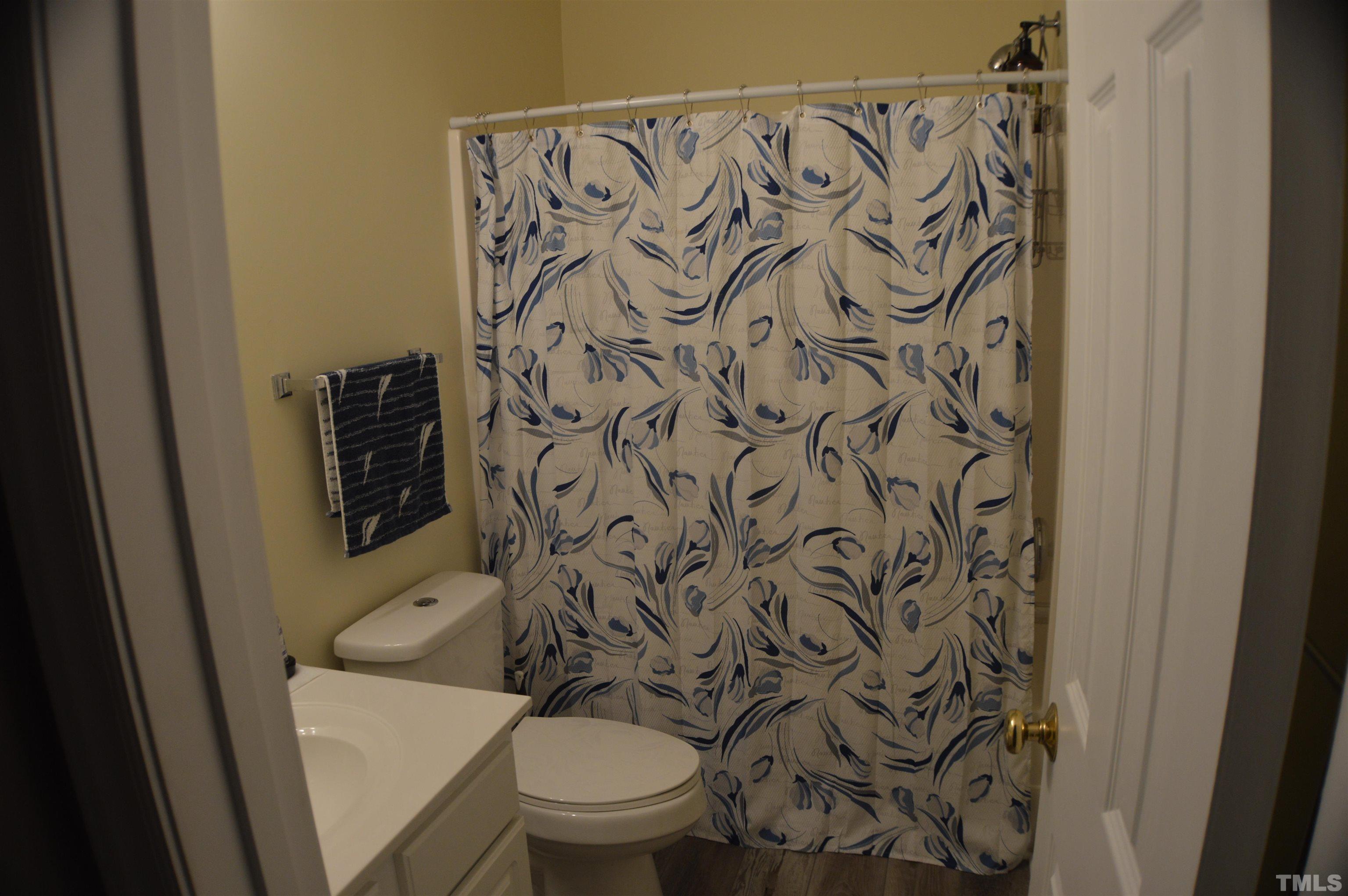 6523 Caverstone Lane Durham, NC 27713 - Photo 17 of 29 a white toilet sitting next to a shower curtain