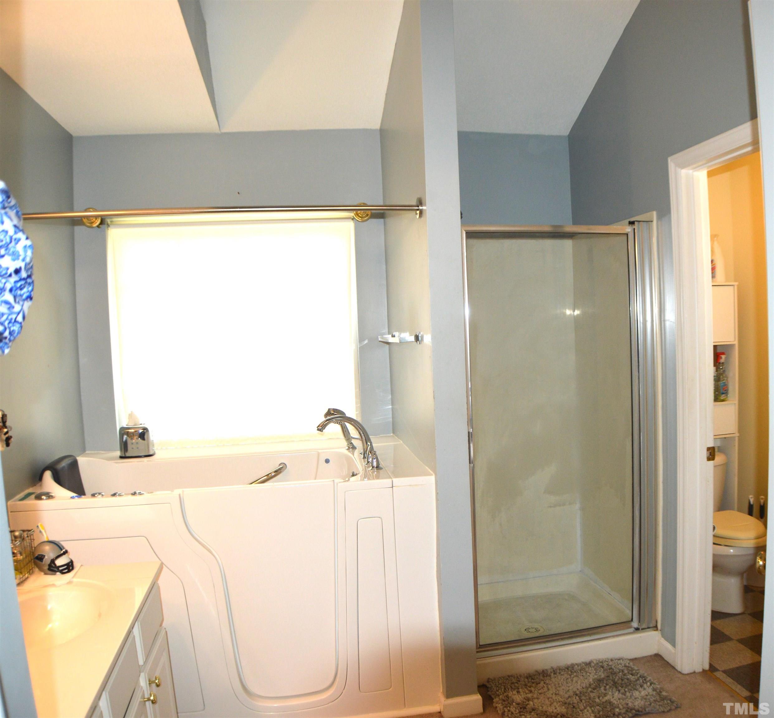 6523 Caverstone Lane Durham, NC 27713 - Photo 23 of 29 a bathroom with a bathtub and a shower