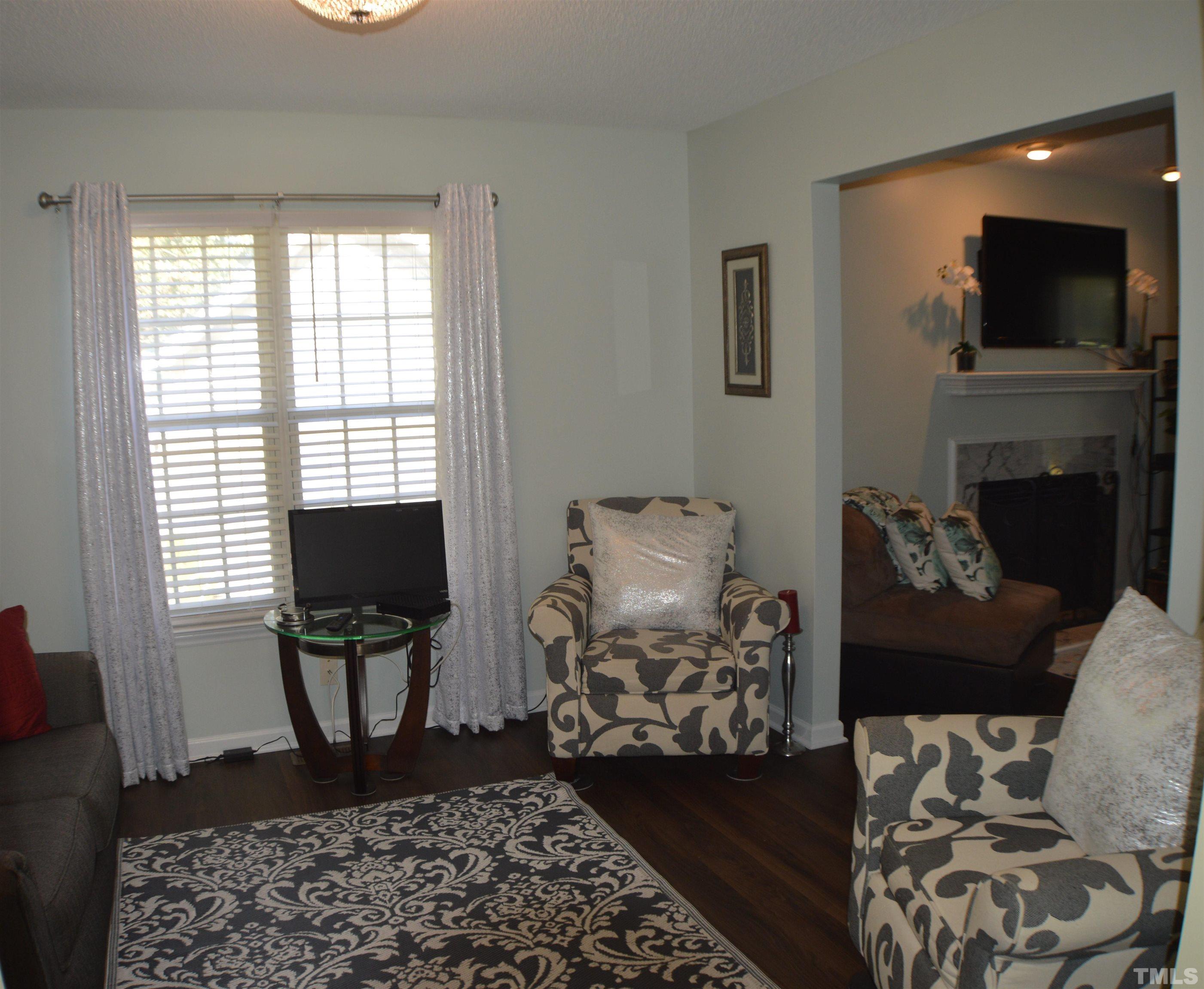 6523 Caverstone Lane Durham, NC 27713 - Photo 5 of 29 a living room with furniture a flat screen tv and a fireplace