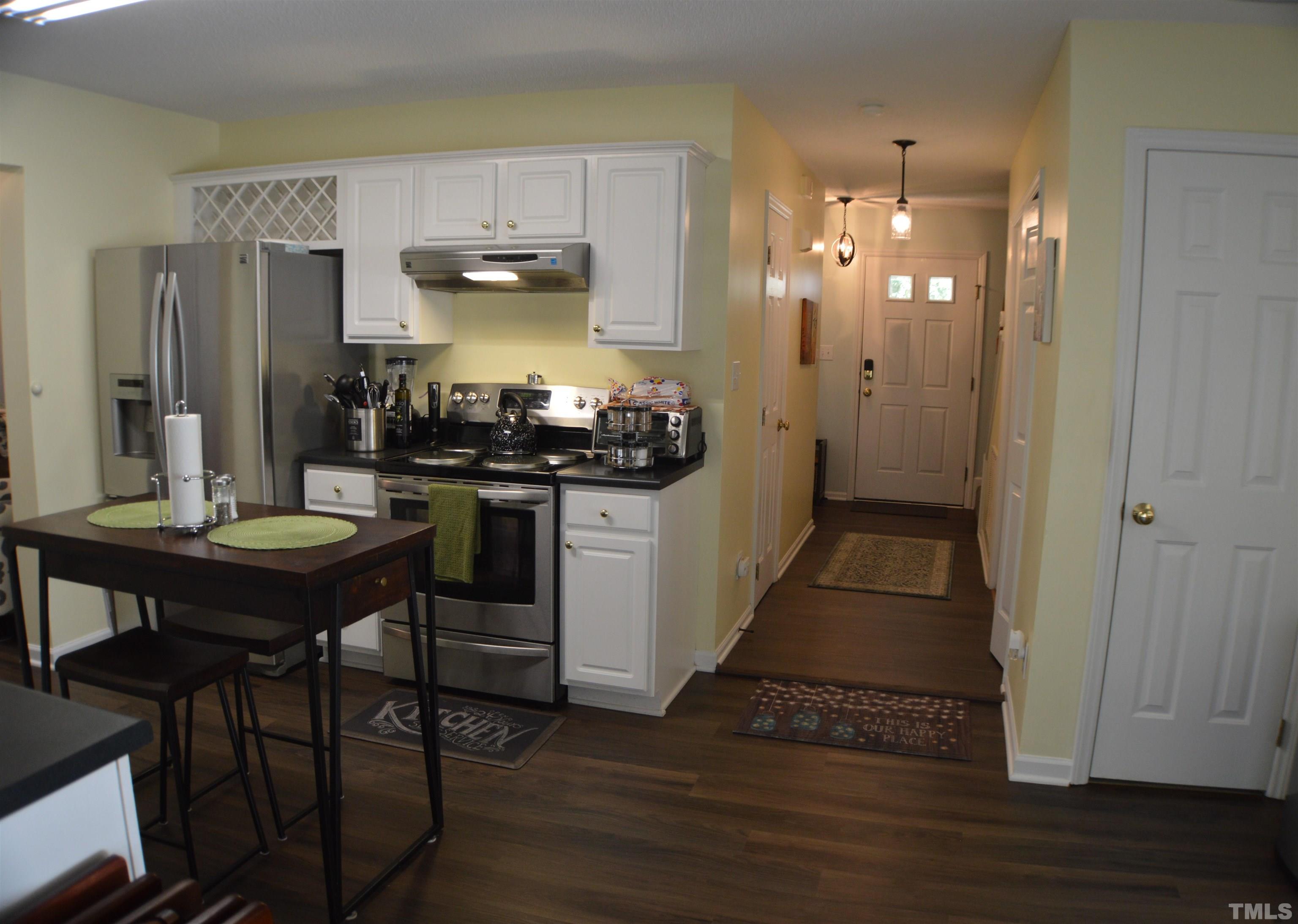 6523 Caverstone Lane Durham, NC 27713 - Photo 8 of 29 a kitchen with stainless steel appliances a stove a table and chairs