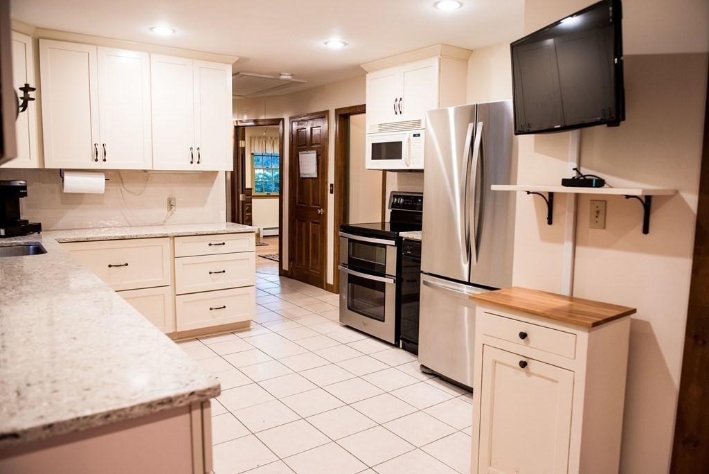 39 George Brown Street Billerica, MA 01821 - Photo 5 of 29 a kitchen with stainless steel appliances kitchen island sink refrigerator and microwave