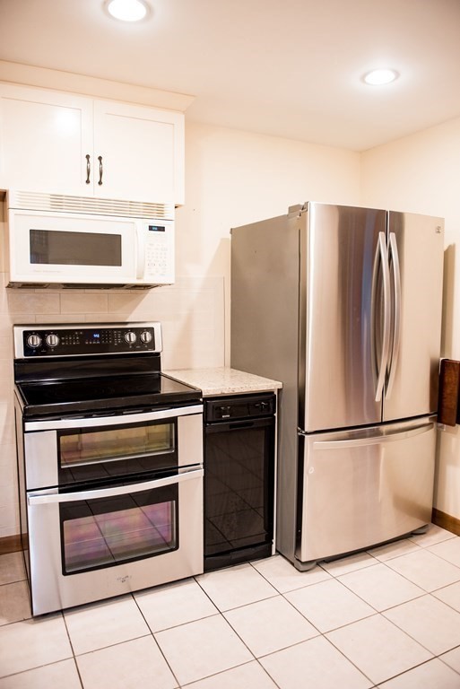 39 George Brown Street Billerica, MA 01821 - Photo 7 of 29 a kitchen with granite countertop a refrigerator and a stove top oven