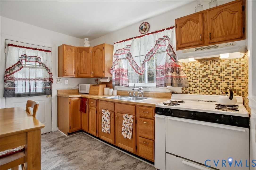 6266 Richmond Road Williamsburg, VA 23188 - Photo 17 of 27 a kitchen with stainless steel appliances granite countertop a sink stove and cabinets