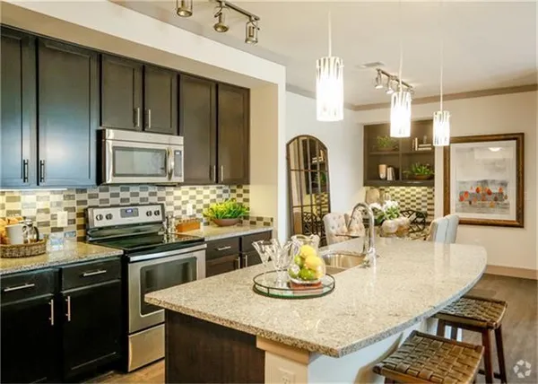 a kitchen with granite countertop stainless steel appliances a sink stove and refrigerator