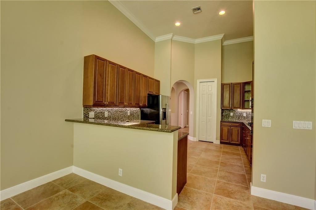 10295 Trianon Place Wellington, FL 33449 - Photo 8 of 26 a kitchen with stainless steel appliances granite countertop a refrigerator and a stove top oven