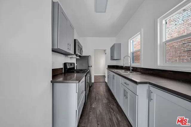 a kitchen with stainless steel appliances granite countertop a sink a stove and a refrigerator