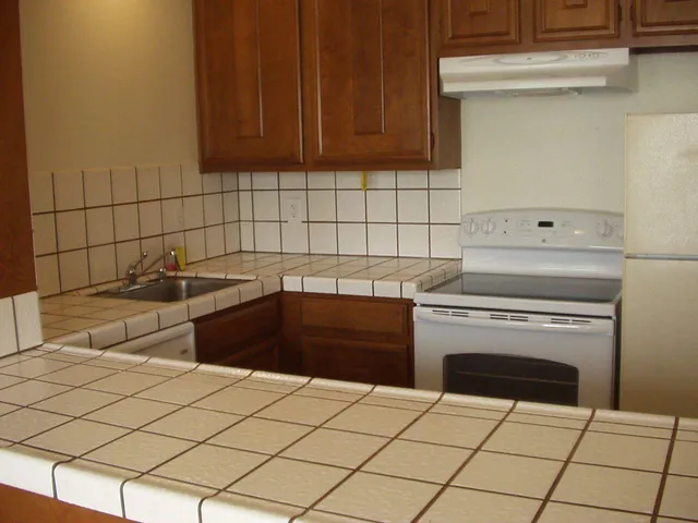 a kitchen with granite countertop white cabinets and white appliances