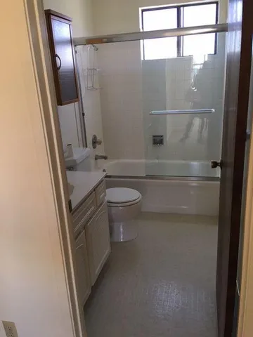 a bathroom with a granite countertop sink toilet and shower