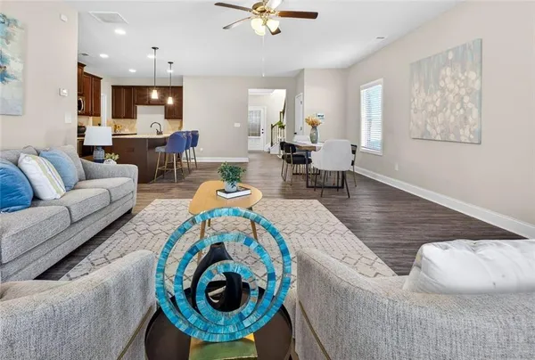a kitchen with granite countertop kitchen island stainless steel appliances a dining table chairs sink and microwave