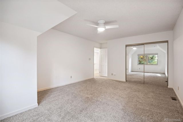 an empty room with fan and windows